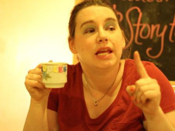 a white woman holding a tea cup and pointing
